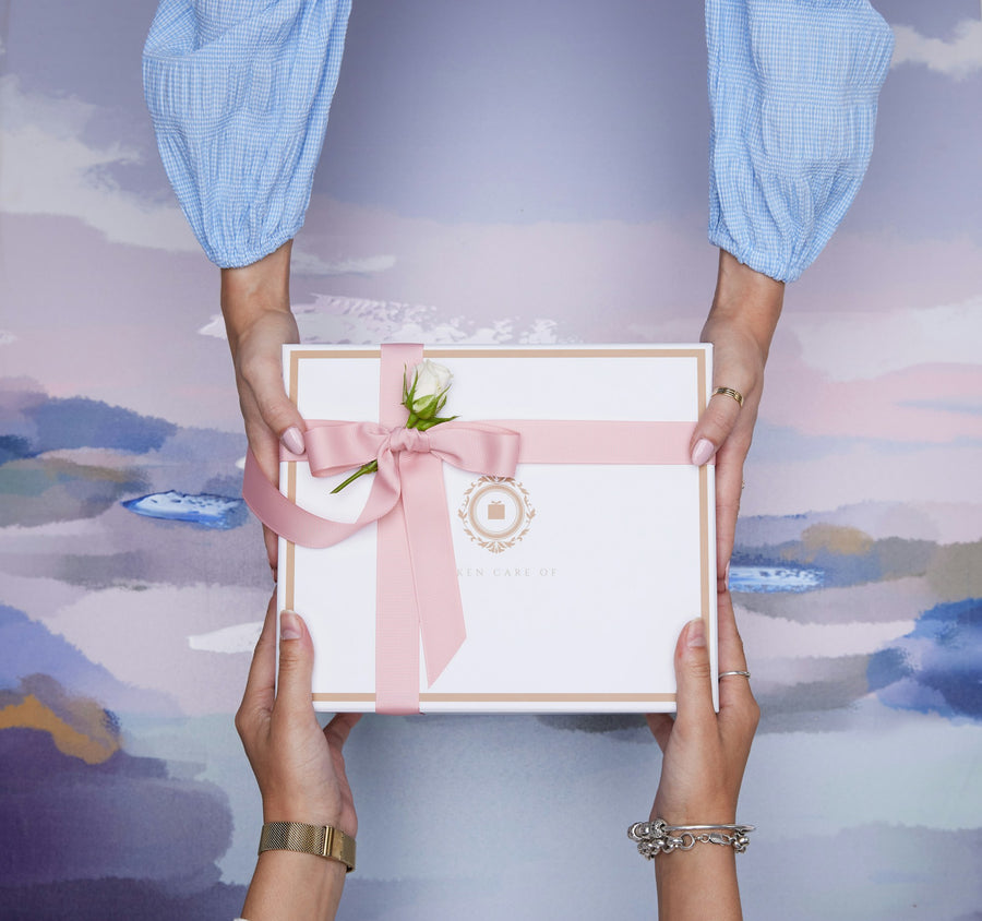 Two hands passing a wrapped gift box